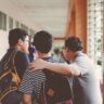 Group of male teenagers walking in a school corridor with backpacks, bonding and chatting.