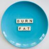 A conceptual image featuring the words 'Burn Fat' on a blue plate, symbolizing weight loss.