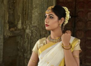 Beautiful Indian woman in traditional saree, adorned with exquisite jewelry, set against historic architecture.